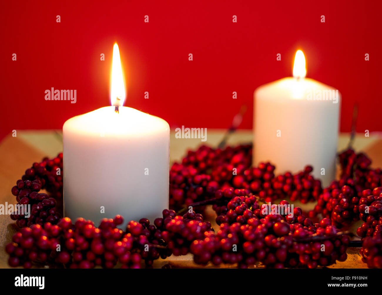 Acceso candele per natale su sfondo rosso Foto Stock