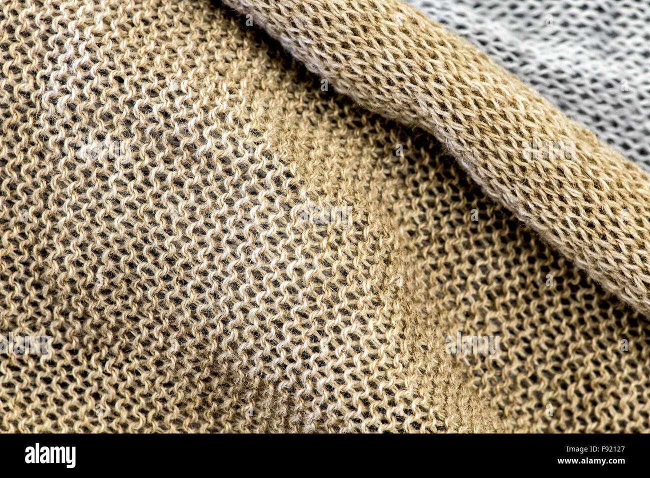 Abstract Background tessile - dettaglio del metallizzato oro tessuto a maglia con strati di maglia bianca in background Foto Stock