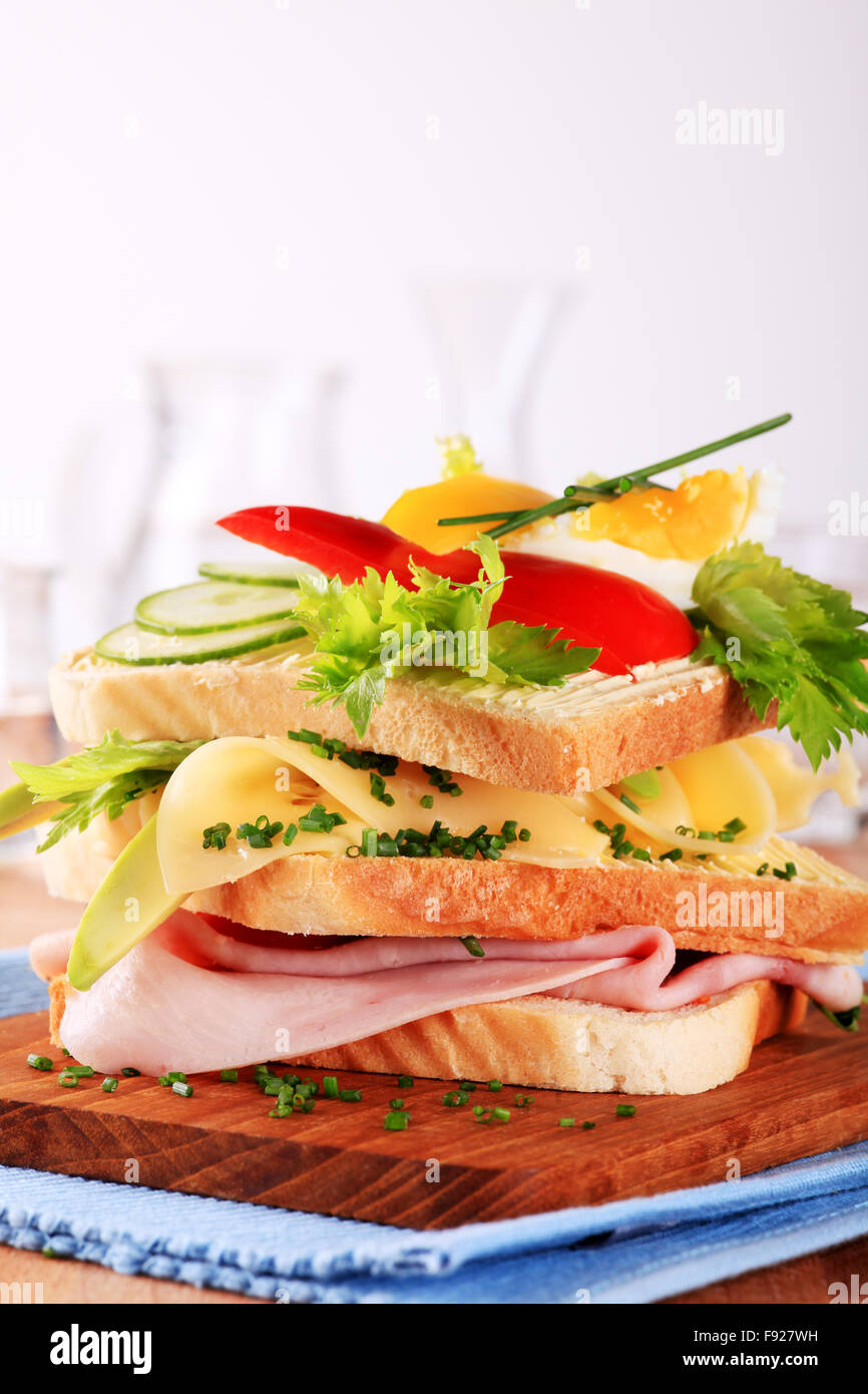 Prosciutto e formaggio panino guarnito con verdure fresche Foto Stock