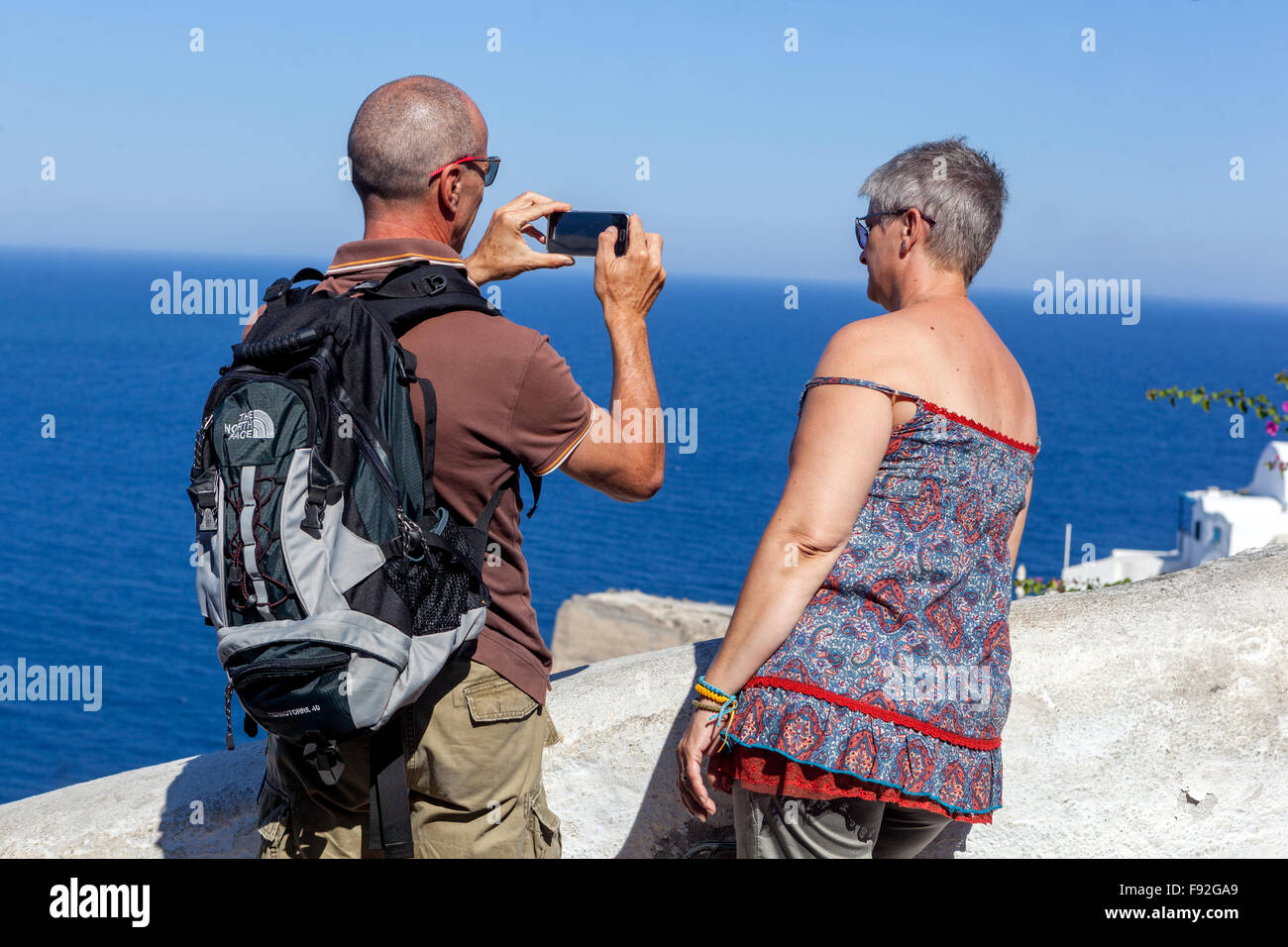 Active Aging Senior coppie turisti che scattano foto adulti anziani pensionati anziani anziani anziani pensionati anziani donne Isole greche Oia Santorini Grecia Europa Foto Stock