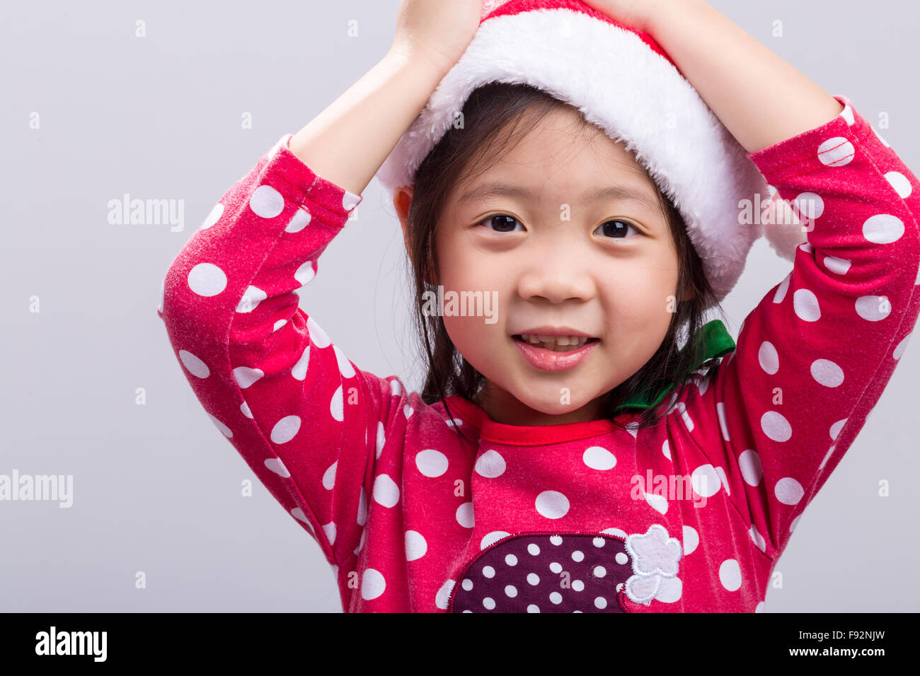 Carino bambino asiatico in Xmas costume rosso. Foto Stock