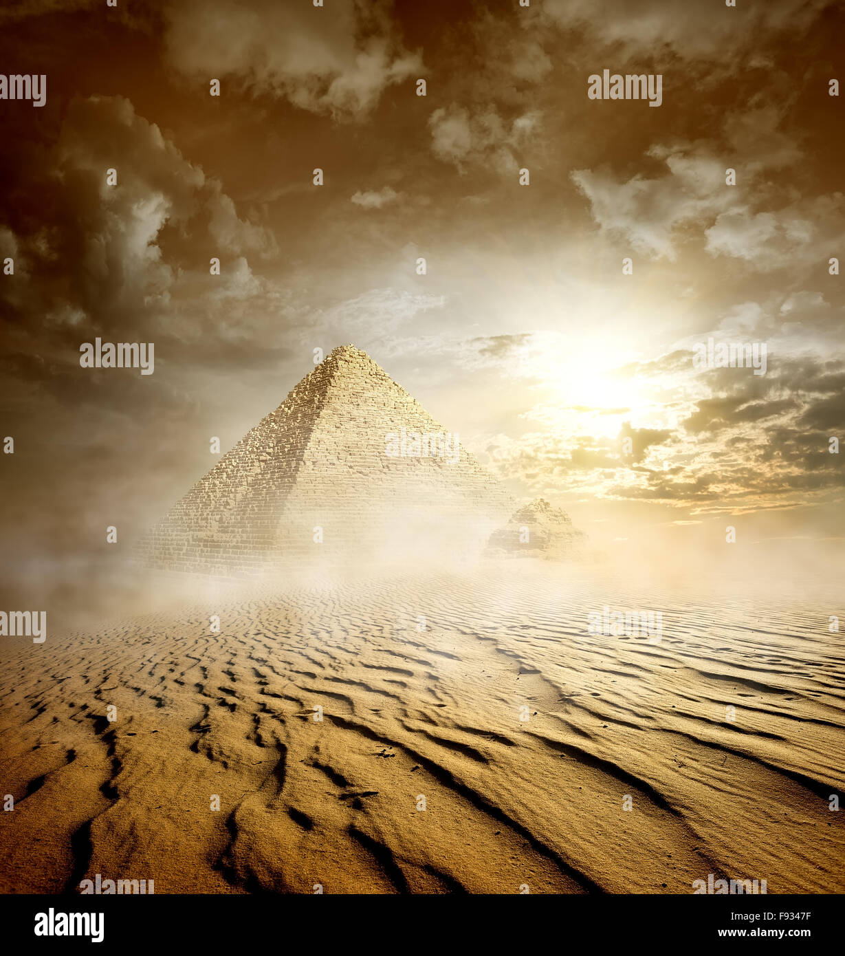 Nuvole temporalesche e Piramidi nel deserto di sabbia Foto Stock