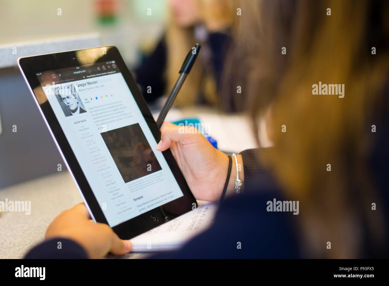 Istruzione secondaria Wales UK: studente gli studenti usando la tecnologia dell informazione (l'iPad di Apple Computer tablet) per la ricerca di vita e di lavoro di George Mendel in una classe di scienze lezione Foto Stock