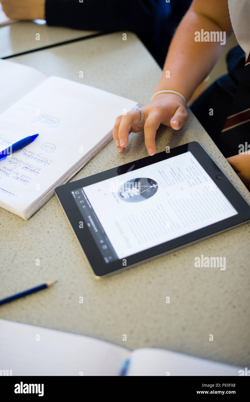 Istruzione secondaria Wales UK: studente gli studenti usando la tecnologia dell informazione (l'iPad di Apple Computer tablet) per la ricerca di vita e di lavoro di George Mendel in una classe di scienze lezione Foto Stock