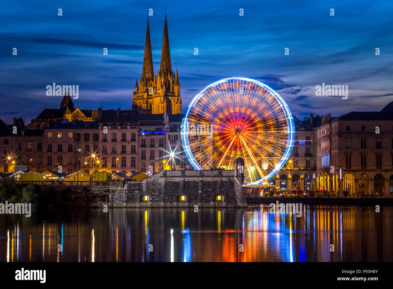 Di notte, una grande ruota (ruota panoramica Ferris) mirroring in acqua all'Adour e Nive confluenza del fiume (Bayonne - Aquitaine - Francia). Foto Stock