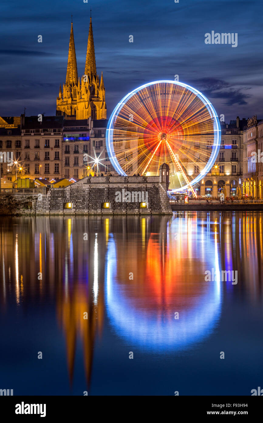 Di notte, una grande ruota (ruota panoramica Ferris) riflettendo in acqua all'Adour e Nive confluenza del fiume (Bayonne - Aquitaine - Francia). Foto Stock