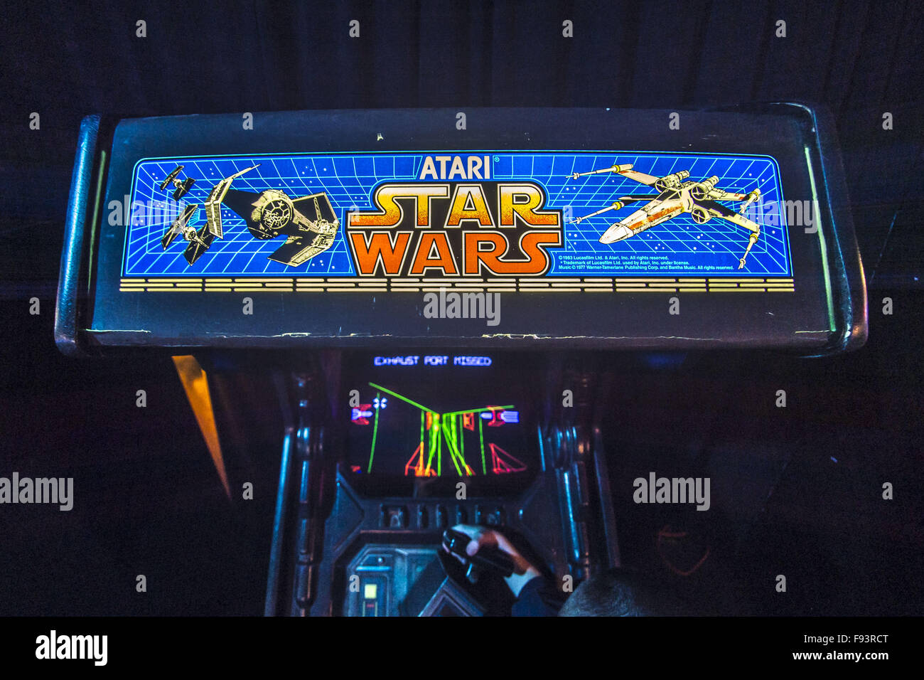 Città Giardino, New York, Stati Uniti d'America. 12 Dic, 2015. Giovane gioca Atari STAR WARS, un 1983 di Lucasfilm Ltd e Atari Inc classico gioco arcade, visto da di overhead, durante il giorno di apertura di età Arcade presentano in set arcade fino alla base del Museo dell'aviazione di Long Island. La mostra interattiva corre da Dic. 12, 2015 attraverso Aprile 3, 2016. © Ann Parry/ZUMA filo/Alamy Live News Foto Stock