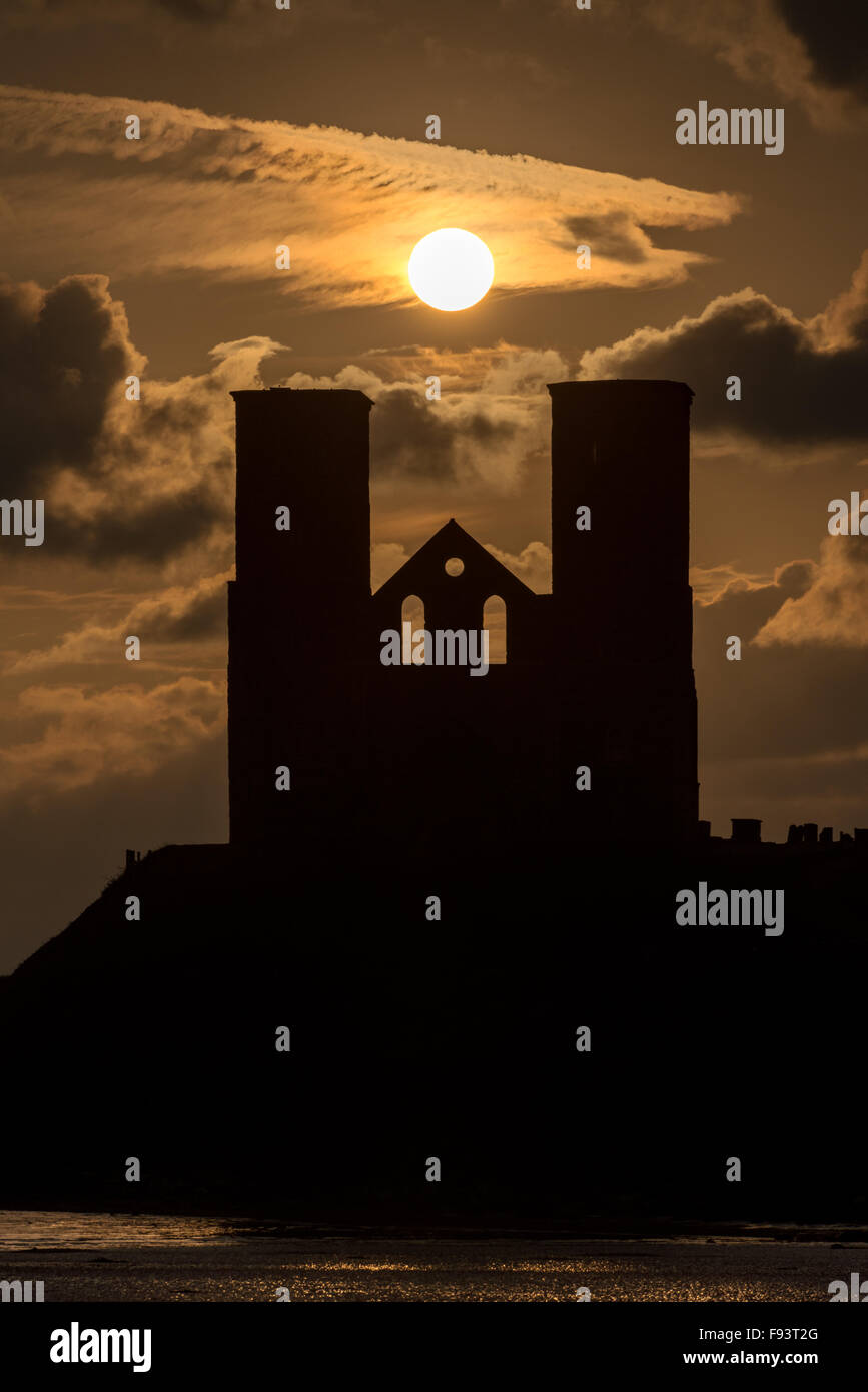 Il sole del mattino catturato fra l'iconica torri gemelle della chiesa di St. Mary a Reculver su alla costa del Kent. Foto Stock