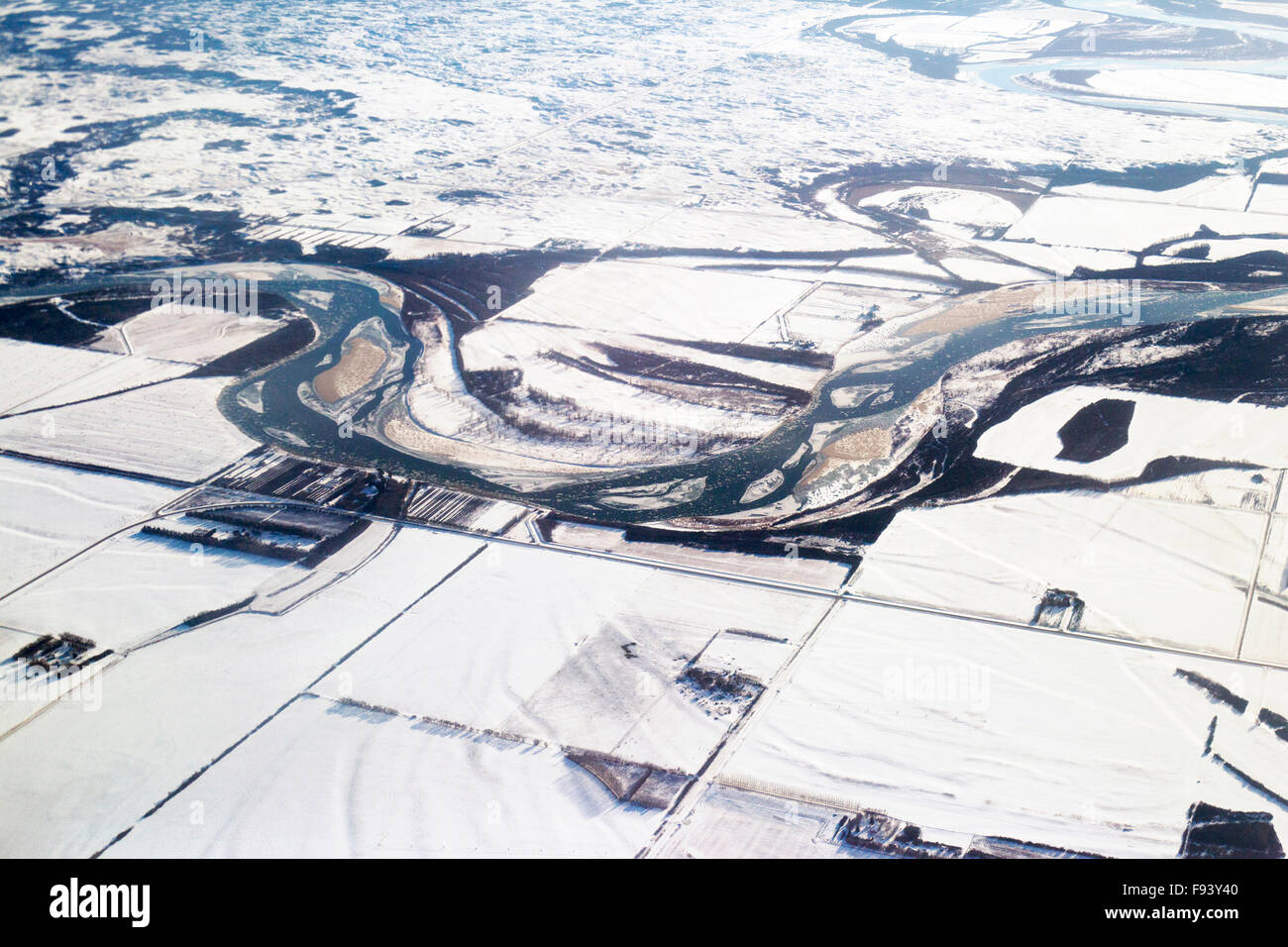 Veduta aerea di paesaggio di prateria coperto di neve con fiume meandering, pianura alluvionale e terreno agricolo in inverno, Saskatchewan Foto Stock