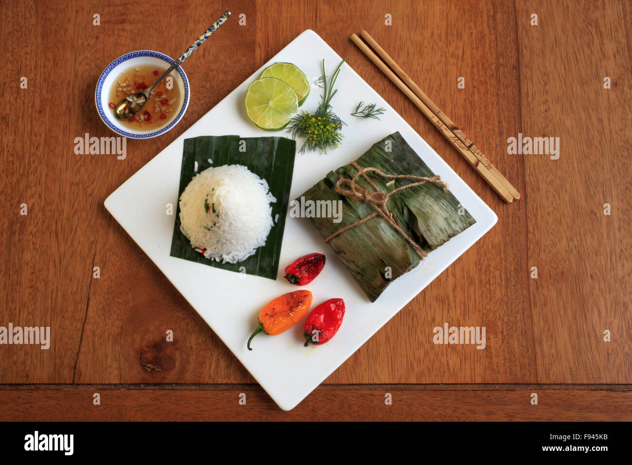 Arrosto di salmone in foglie di banano, piccante aneto e pasta di calce, noce di cocco riso vietnamita, immersione, salsa di peperoni, Foto Stock