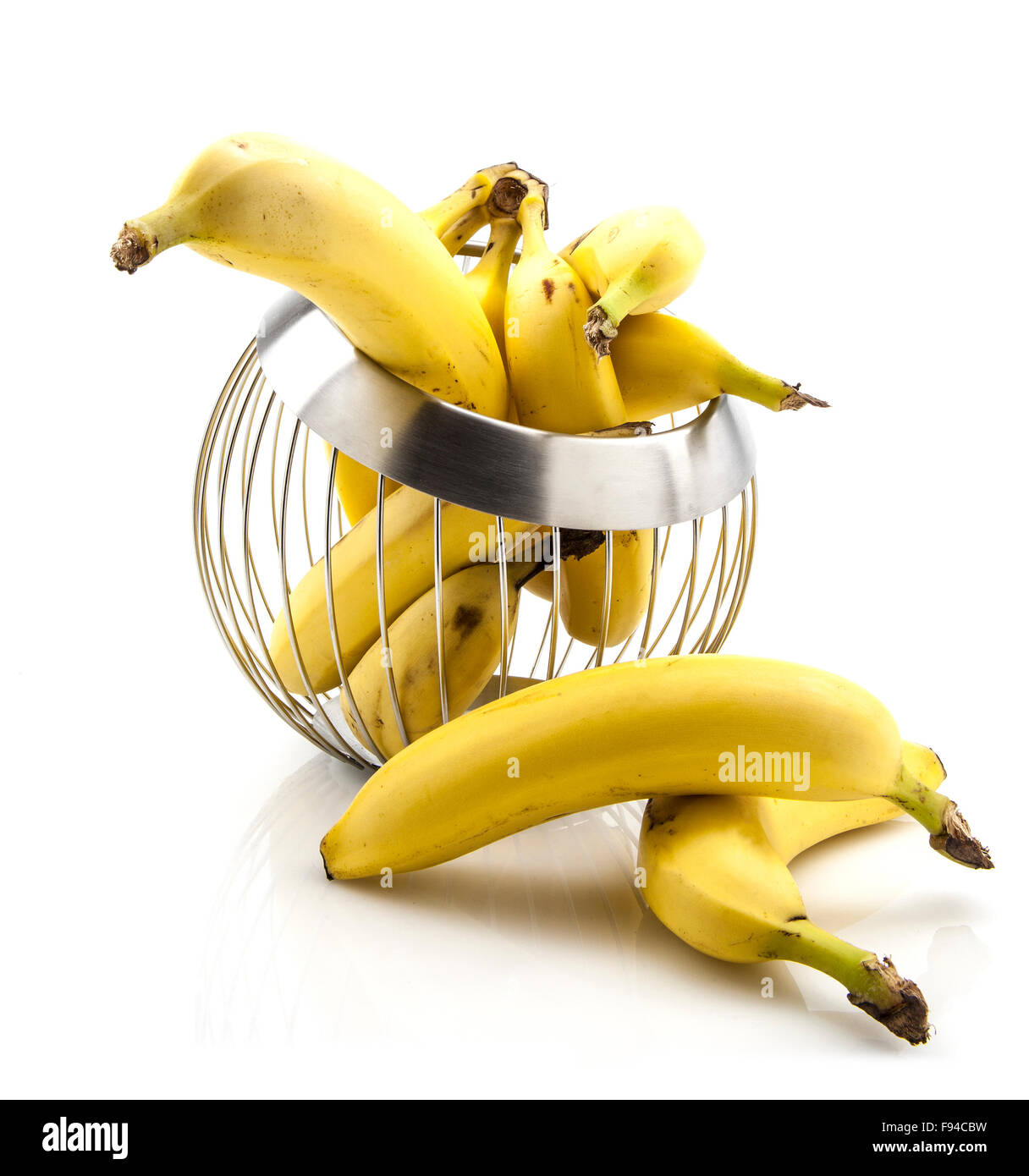 Le banane nel filo cesto di frutta su sfondo bianco Foto Stock