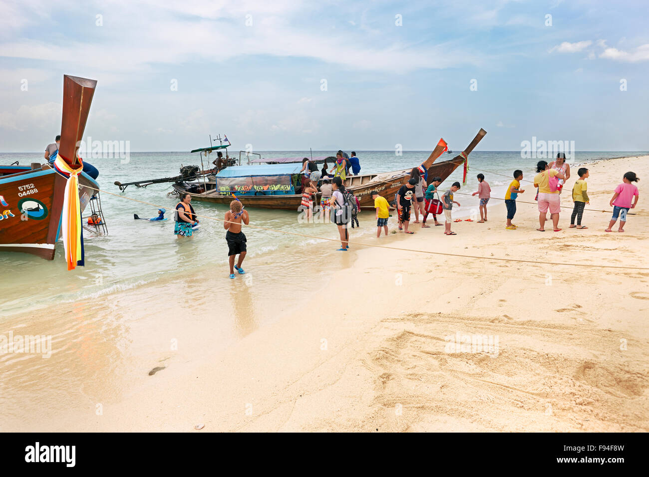 I turisti scendono dalla longtail boat. Poda Island (Koh Poda), Provincia di Krabi, Thailandia. Foto Stock