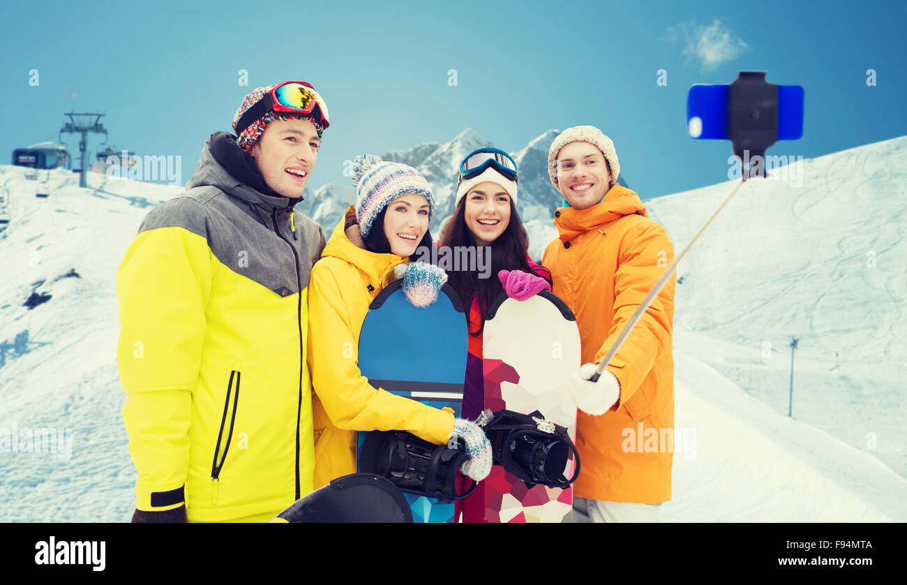 Happy amici con racchette da neve e lo smartphone Foto Stock