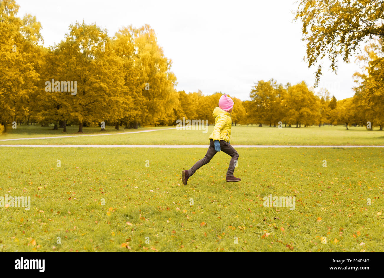 Felice bambina in esecuzione in autunno park Foto Stock