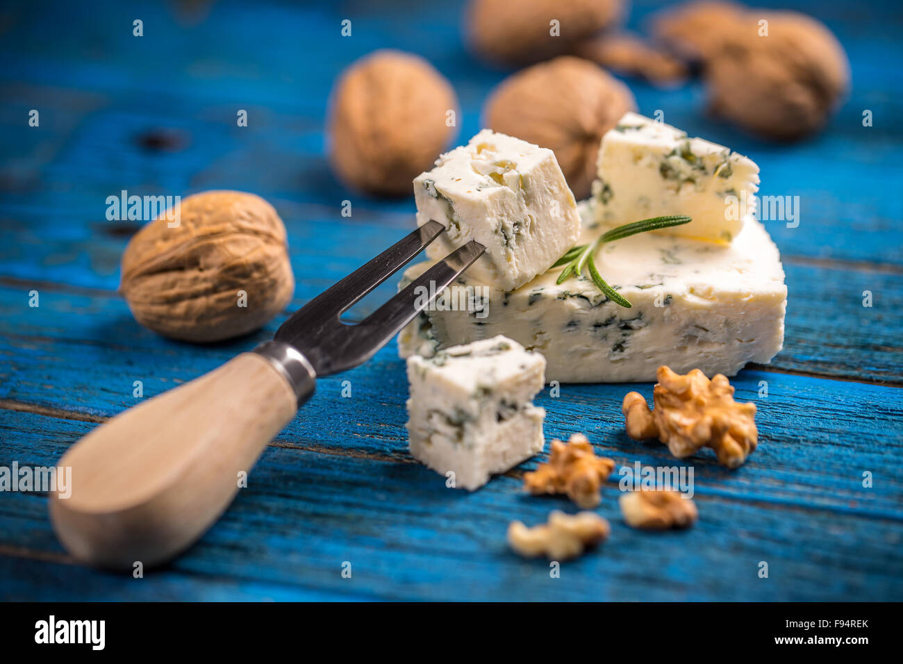 Formaggio blu con i dadi su blu tavolo in legno Foto Stock