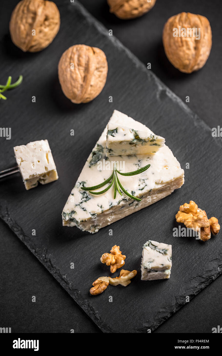 Formaggio blu con i dadi su nero ardesia Foto Stock