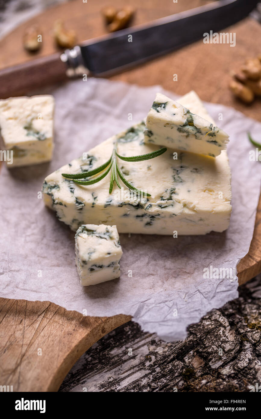 Fetta di blu del formaggio Stilton su un sfondo rustico Foto Stock