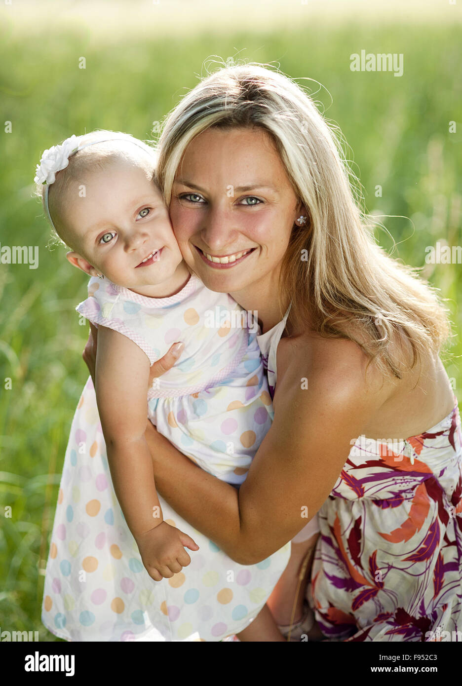 Felice giovane madre divertendosi con la sua piccola figlia in estate la natura Foto Stock