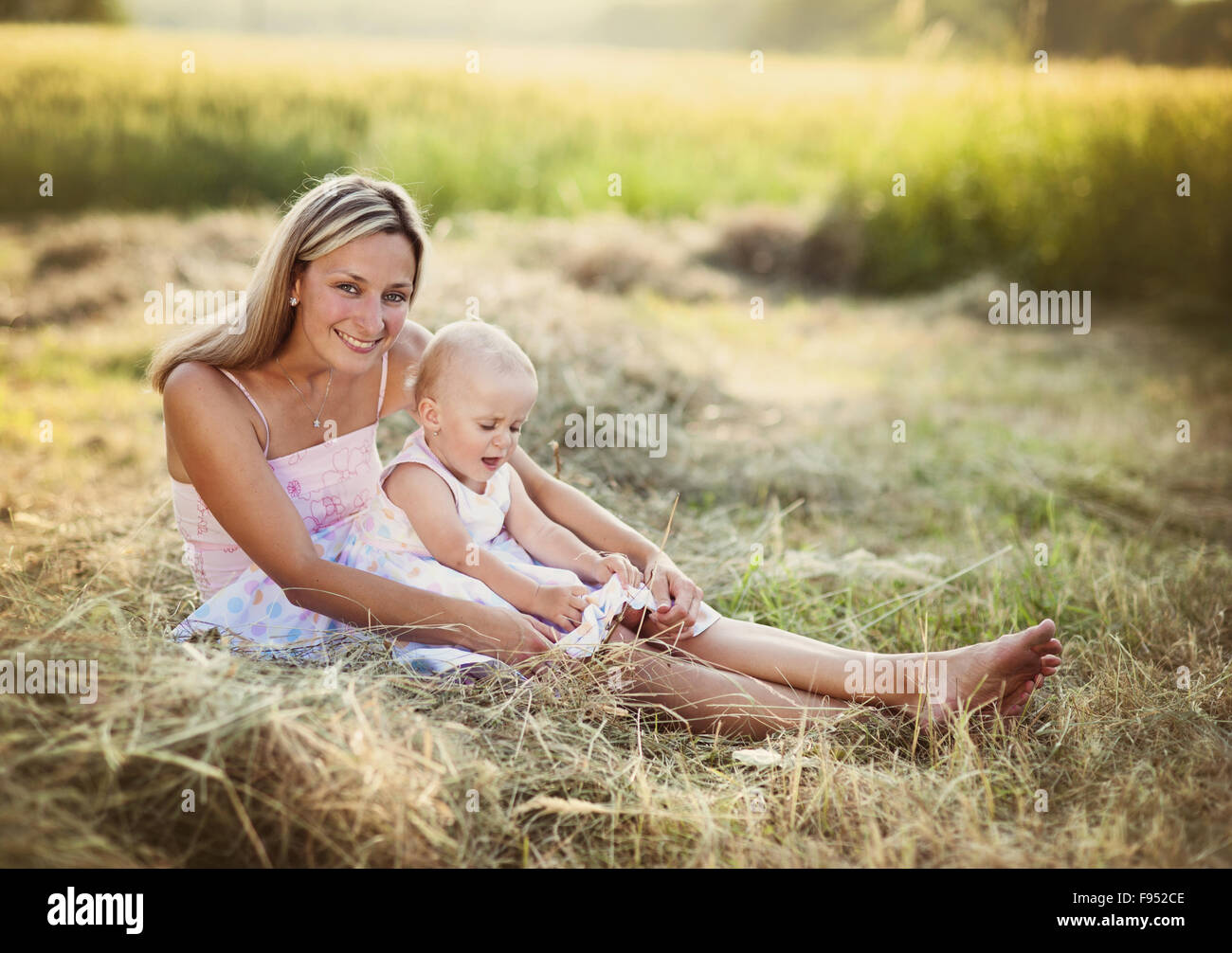 Felice giovane madre divertendosi con la sua piccola figlia in estate la natura Foto Stock