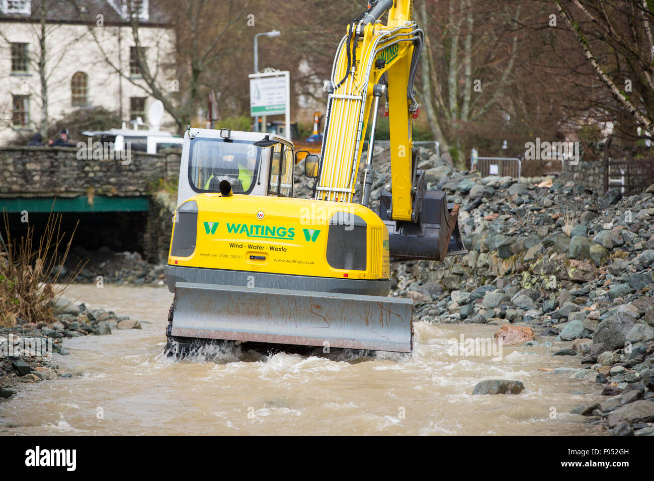 Sabato 5 dicembre 2015, Storm desmond si è schiantato nel Regno Unito, la produzione del Regno Unito più alto mai 24 ore totali di precipitazione a 341.4mm. Ha allagato il Lakeland Village Glenridding, che si stava appena cominciando a riparazione quando un altro periodo di heavy rain per mercoledì 9 dicembre hanno causato la Glenridding Beck di scoppiare le sue banche, provocando ulteriore distruzione. Questa immagine presa sul Venerdì 11 Dicembre mostra un escavatore cercando di cancellare flood i detriti dal fiume. Foto Stock