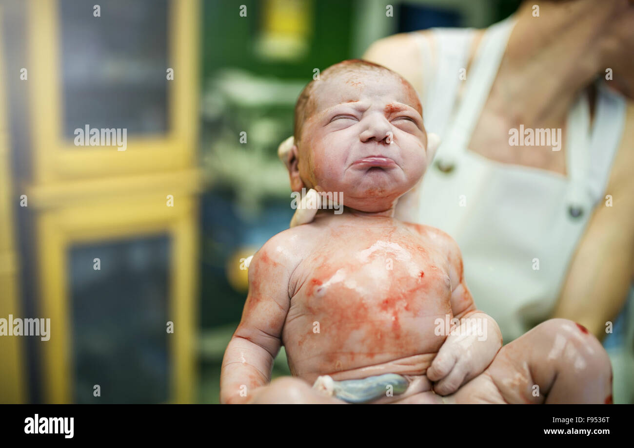 Medico in possesso di una bellissima bambina di pochi secondi dopo la nascita Foto Stock