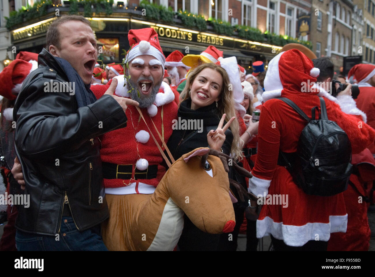 I turisti ottenere fotografati con una di Babbo Natale e Rudolph il naso rosso di renna. SantaCon incontrarsi al di fuori dalla stazione di Liverpool street central city di Londra UK HOMER SYKES Foto Stock