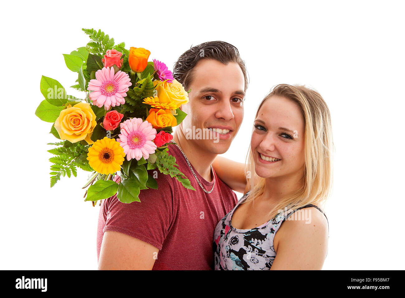 La ragazza è felice con bouquet di fiori dando da ragazzo su sfondo bianco Foto Stock