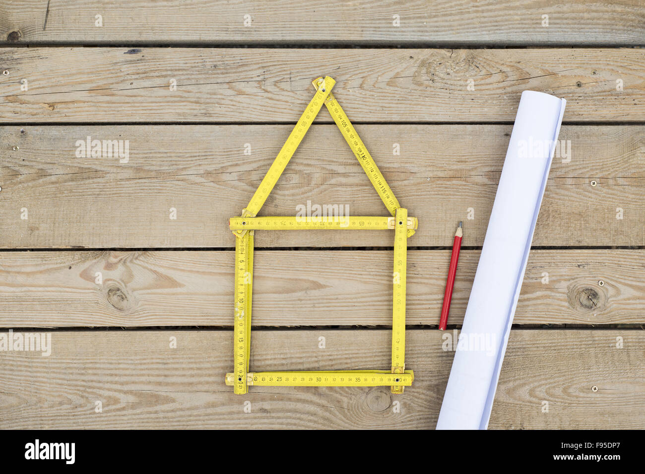 Concetto di casa con metro giallo sul pavimento in legno Foto Stock