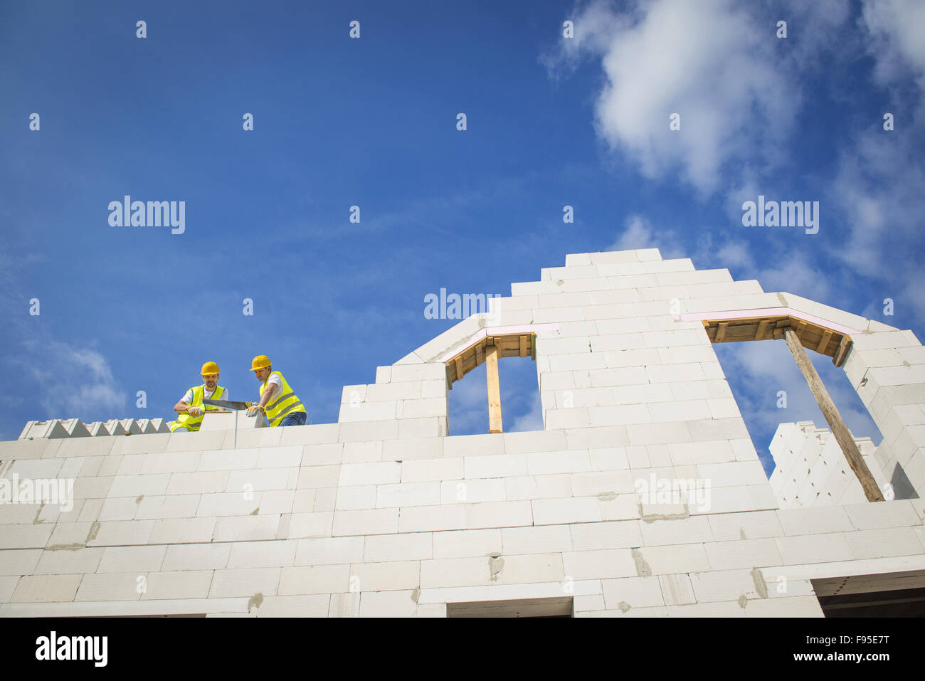 I costruttori stanno lavorando sulla parte superiore della costruzione casa. Foto Stock