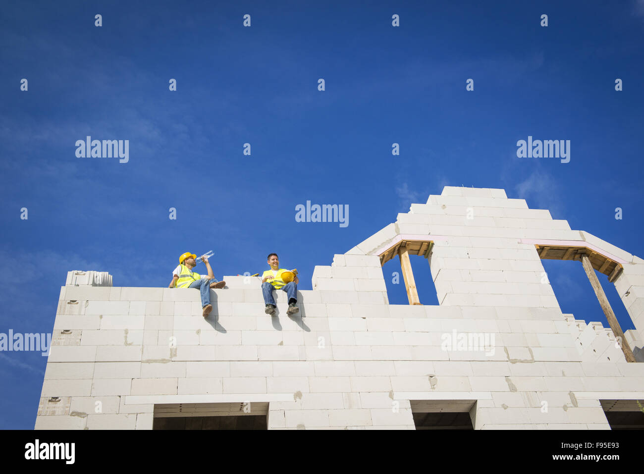 I costruttori stanno lavorando sulla parte superiore della costruzione casa. Foto Stock
