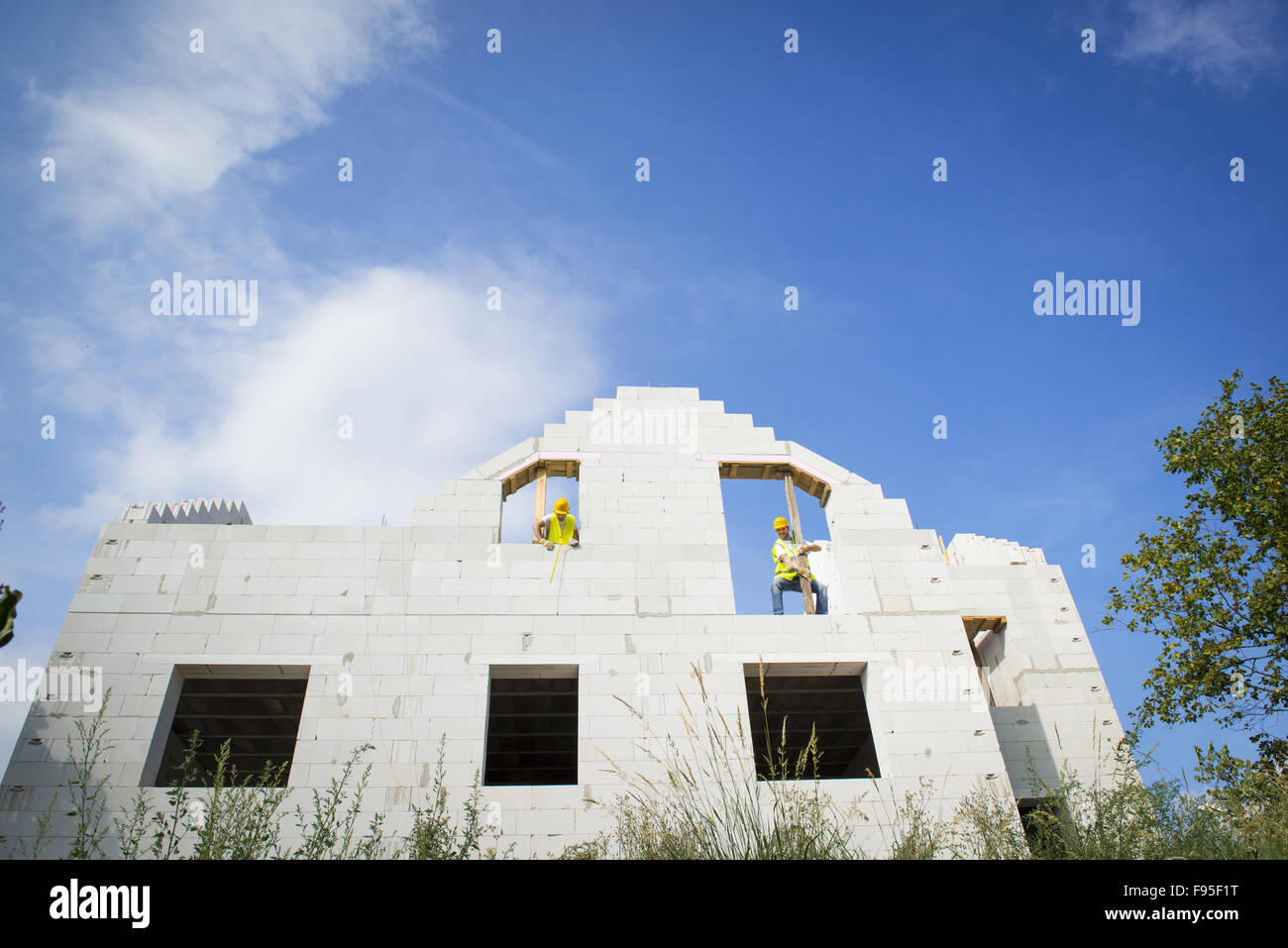 I costruttori stanno lavorando sulla parte superiore della costruzione casa. Foto Stock