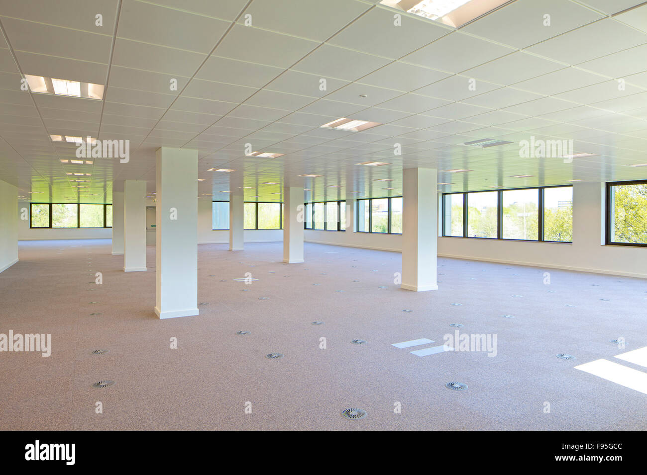 Il Capitol Building, Bracknell. Vista interna di un pavimento vuoto del Campidoglio. Bianche pareti rivestite con windows e le luci del cielo. Luce naturale. Foto Stock