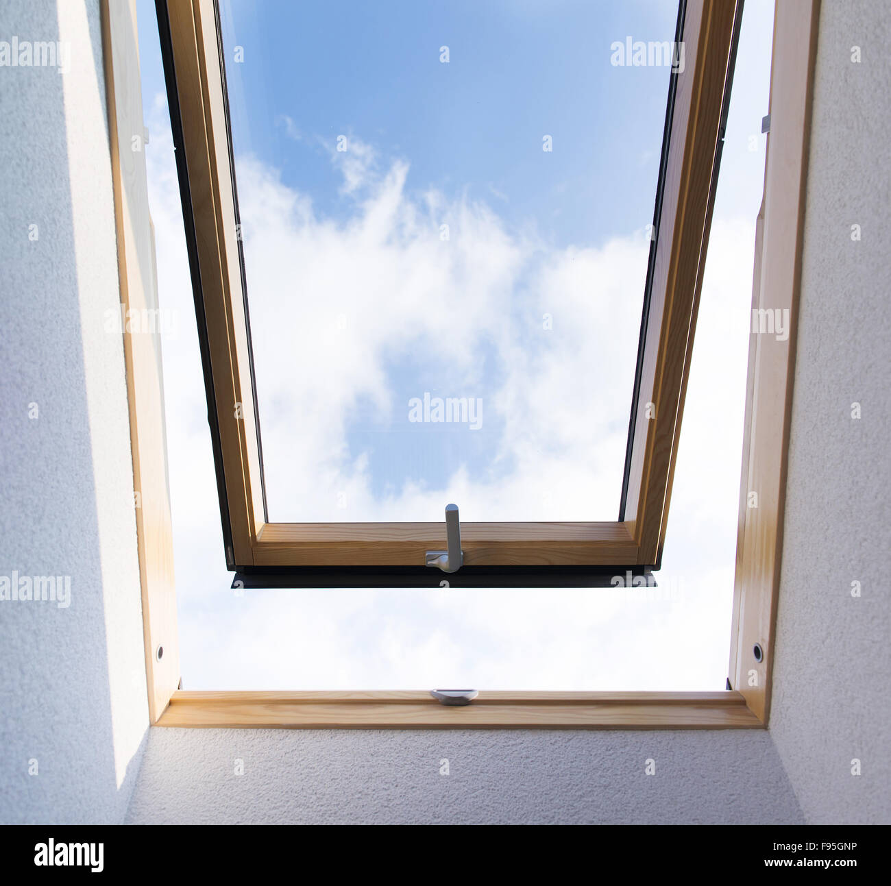 Bella Blu vista cielo attraverso il tetto lucernario finestra in camera mansardata. Foto Stock