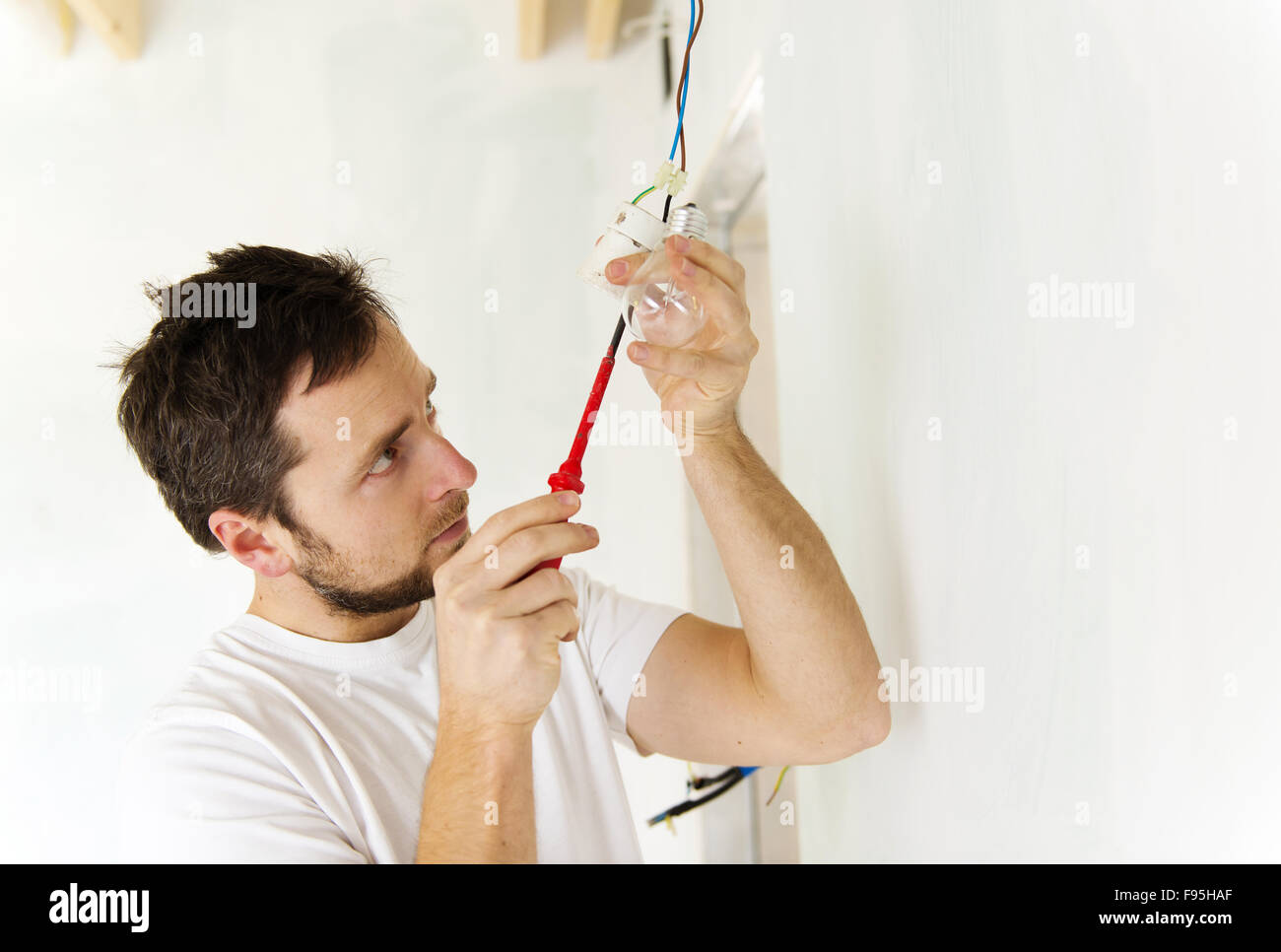 Elettricista installazione di luce in una nuova casa Foto Stock