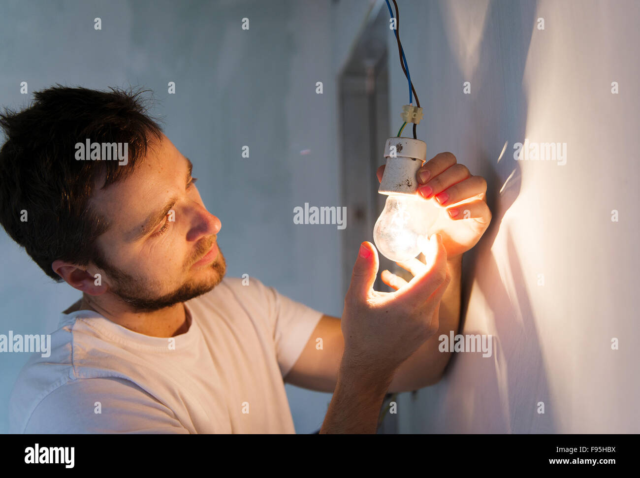 Elettricista installazione di luce in una nuova casa Foto Stock