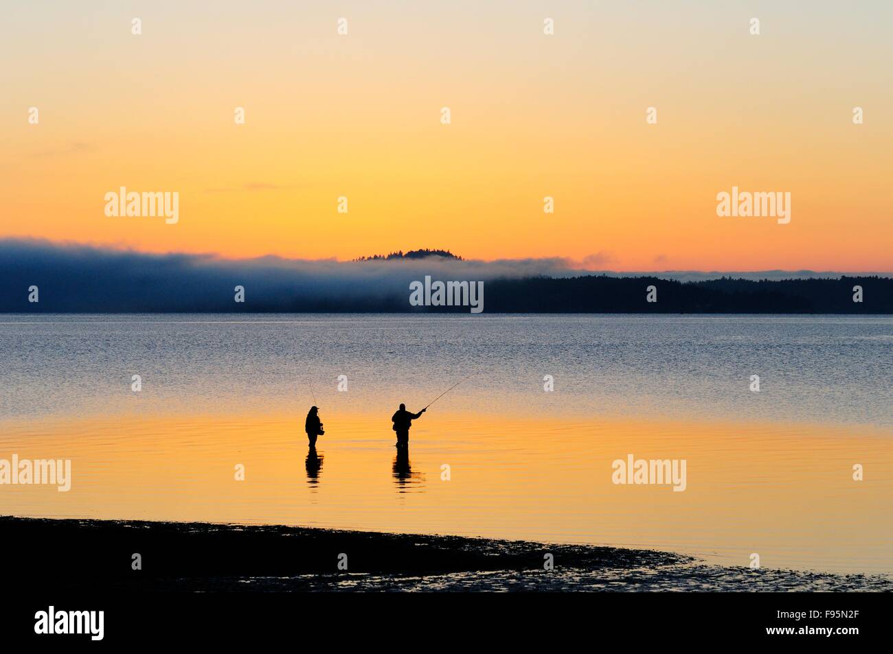 Due uomini Pesca al salmone off Cherry Point spiaggia vicino Cowichan Bay, BC. Foto Stock