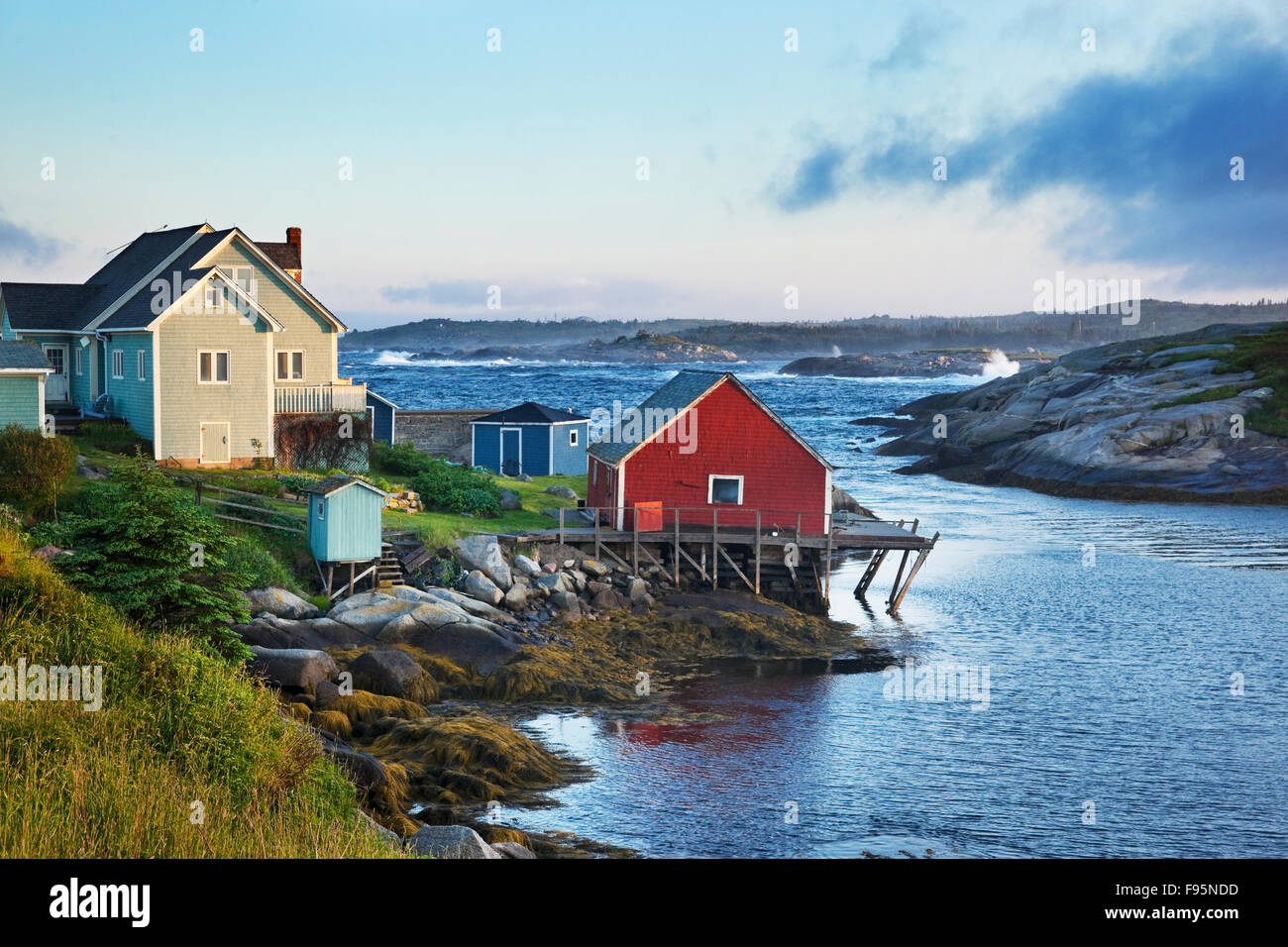 Casa di mare attraverso da rocce e onde che si infrangono in Peggy's Cove, Nova Scotia Foto Stock