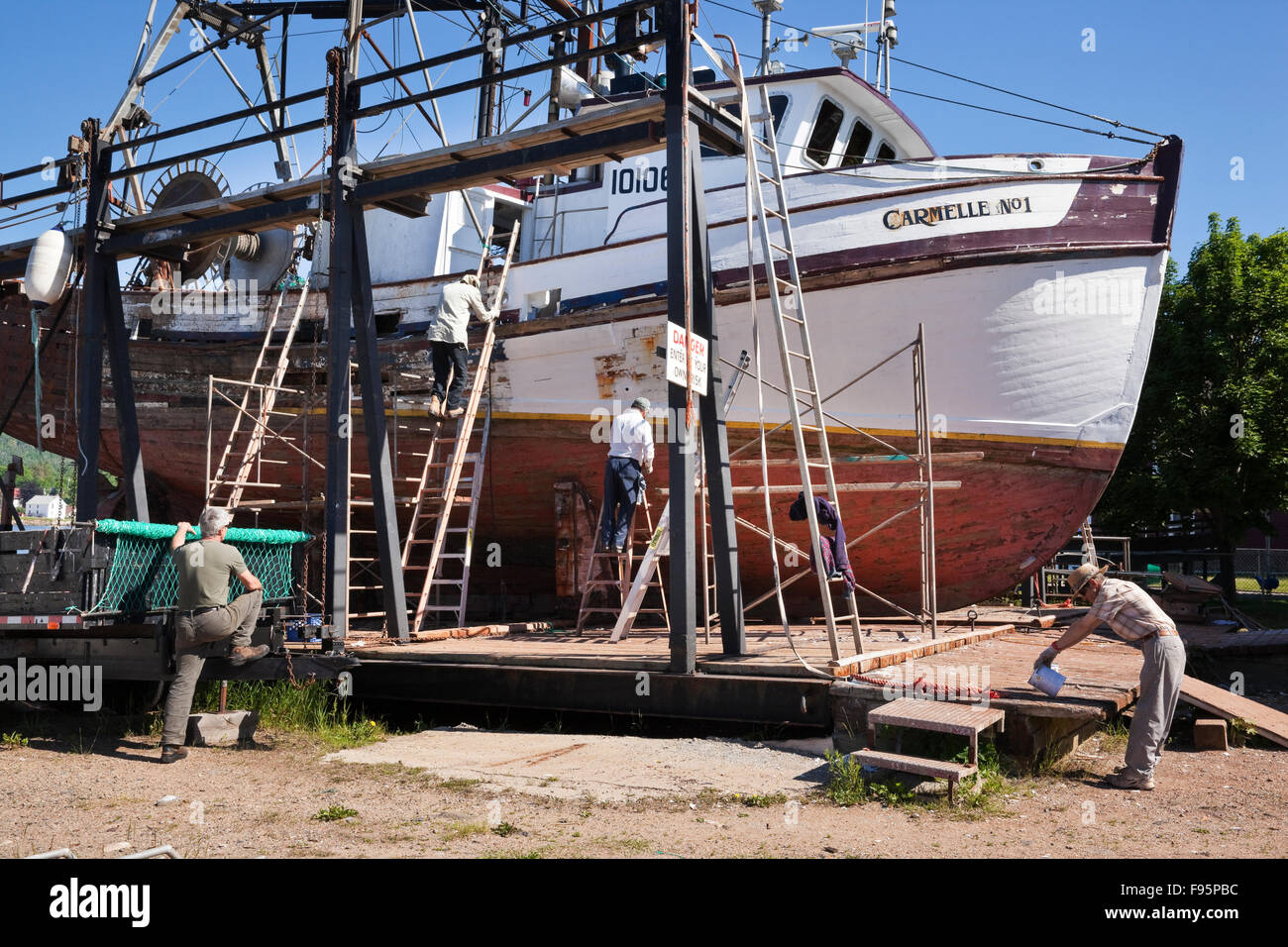 Gli uomini al lavoro la riparazione di una dentellatura barca da pesca utilizzando le formule tradizionali. Annapolis Royal Haulup in barca e cantiere di riparazione, Annapolis Foto Stock