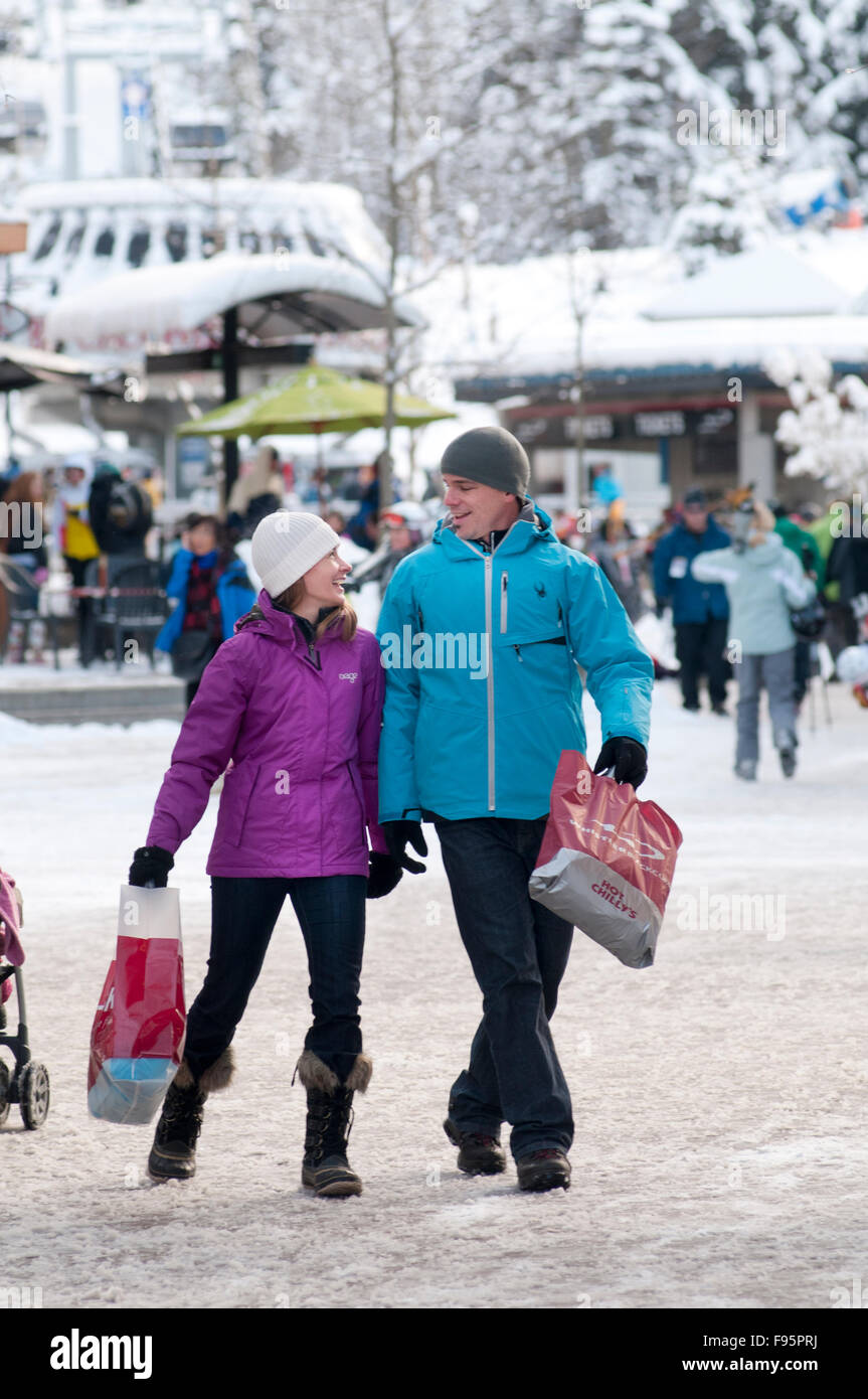 Un giovane gode di passeggiata e shopping Whistler Village su un giorno d'inverno. Foto Stock