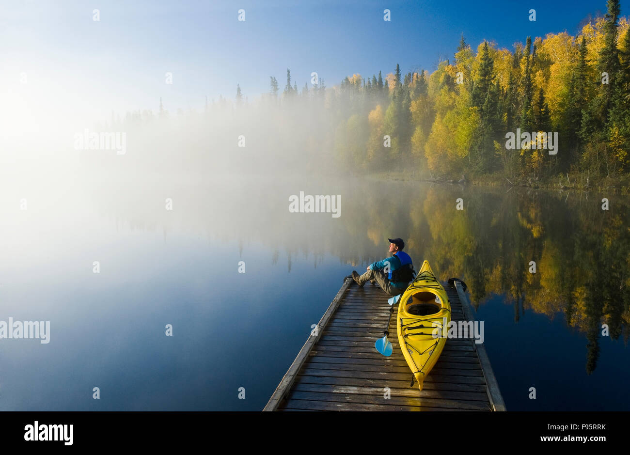 Un uomo sul dock con kayak, Dickens Lago, Northern Saskatchewan, Canada Foto Stock