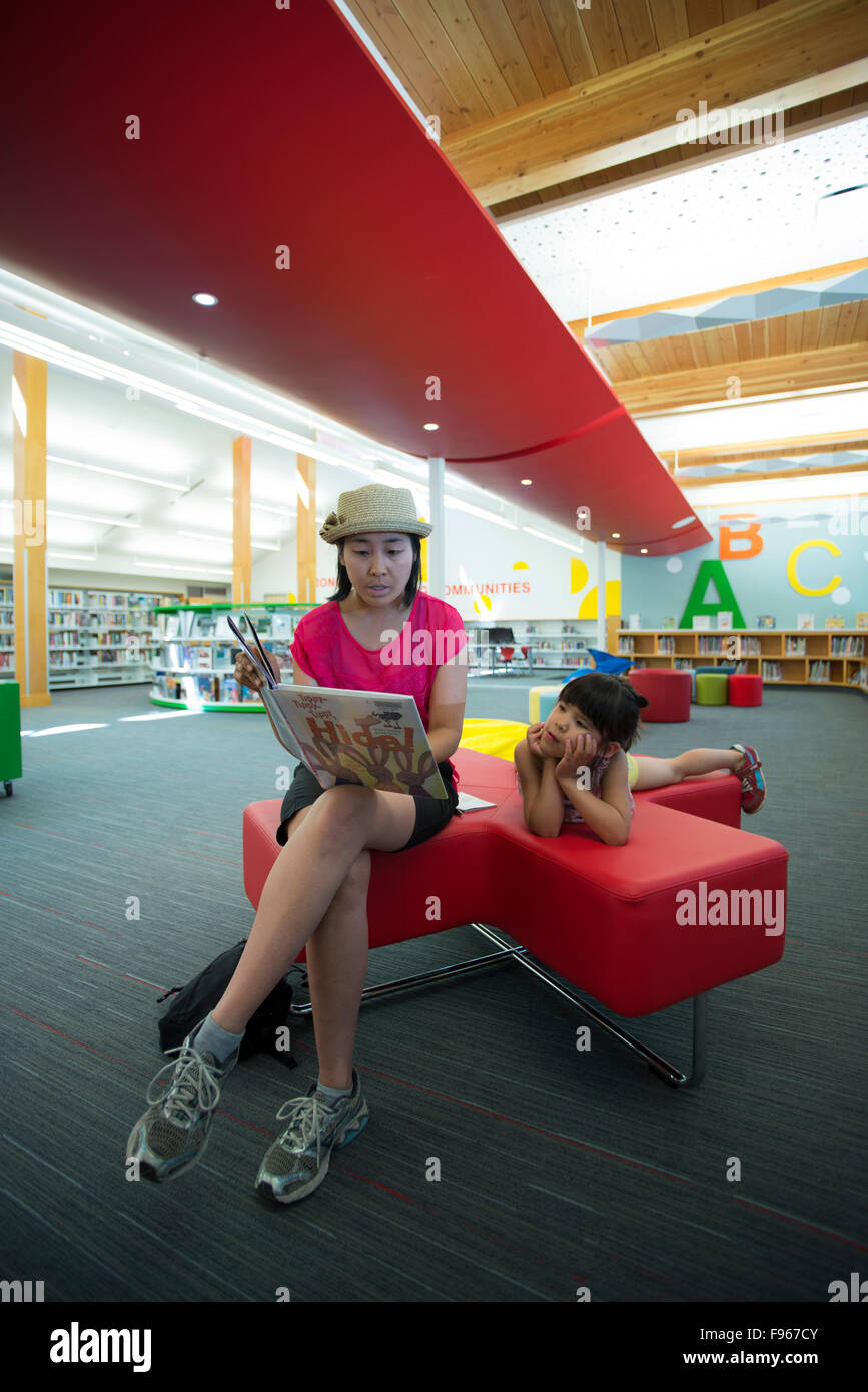 Donna e bambino la lettura di un libro a Vancouver Island Biblioteca Regionale, a nord di Nanaimo filiale. Nanaimo, British Columbia, Foto Stock
