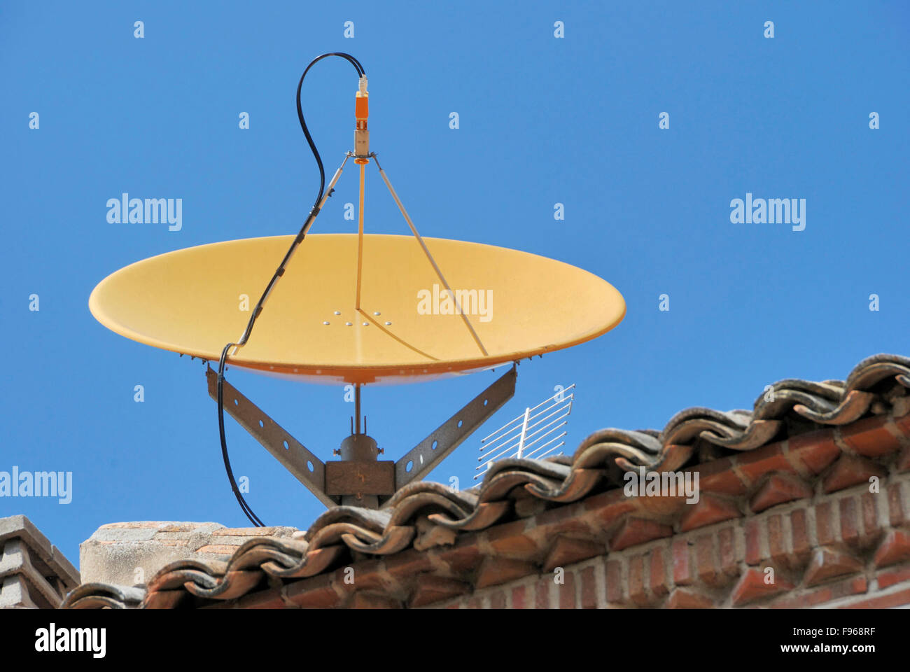 Una parabola satellitare sul tetto di una casa Foto Stock