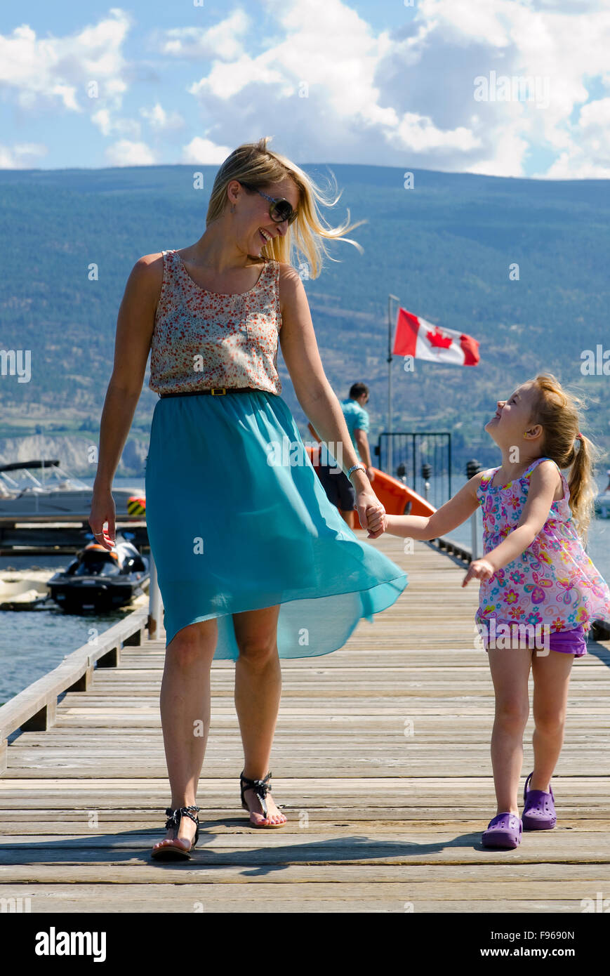 Madre e figlia giovane di godere di un caldo pomeriggio estivo a piedi in Summerland al Waterfront Resort, nel sud Okanagan Foto Stock