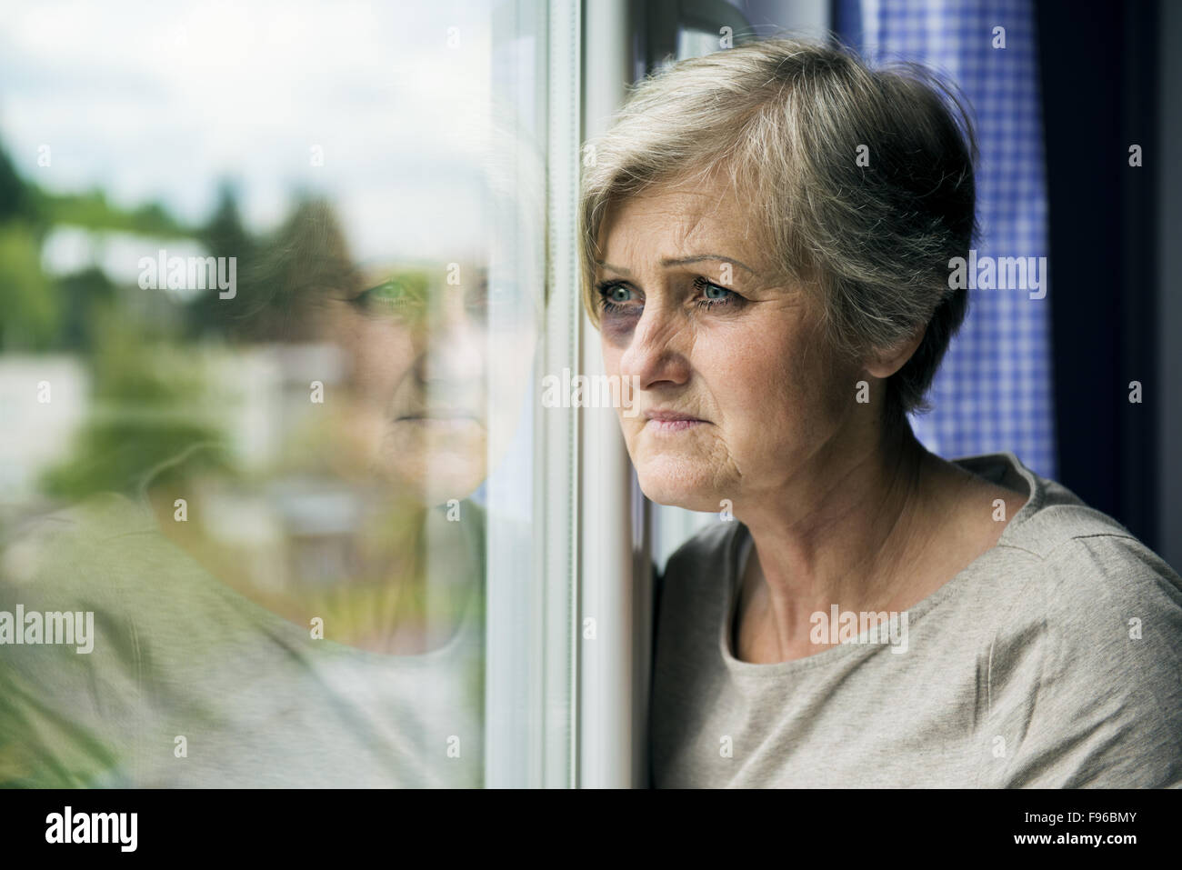 La paura della donna si cerca attraverso la finestra. Avente livido sul suo viso Foto Stock