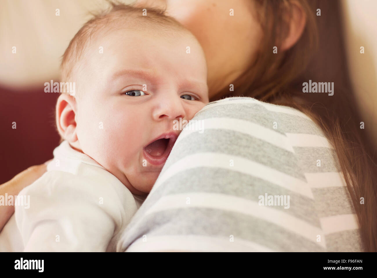 Carino neonato ragazzo in un momento di relax a casa con sua madre Foto Stock