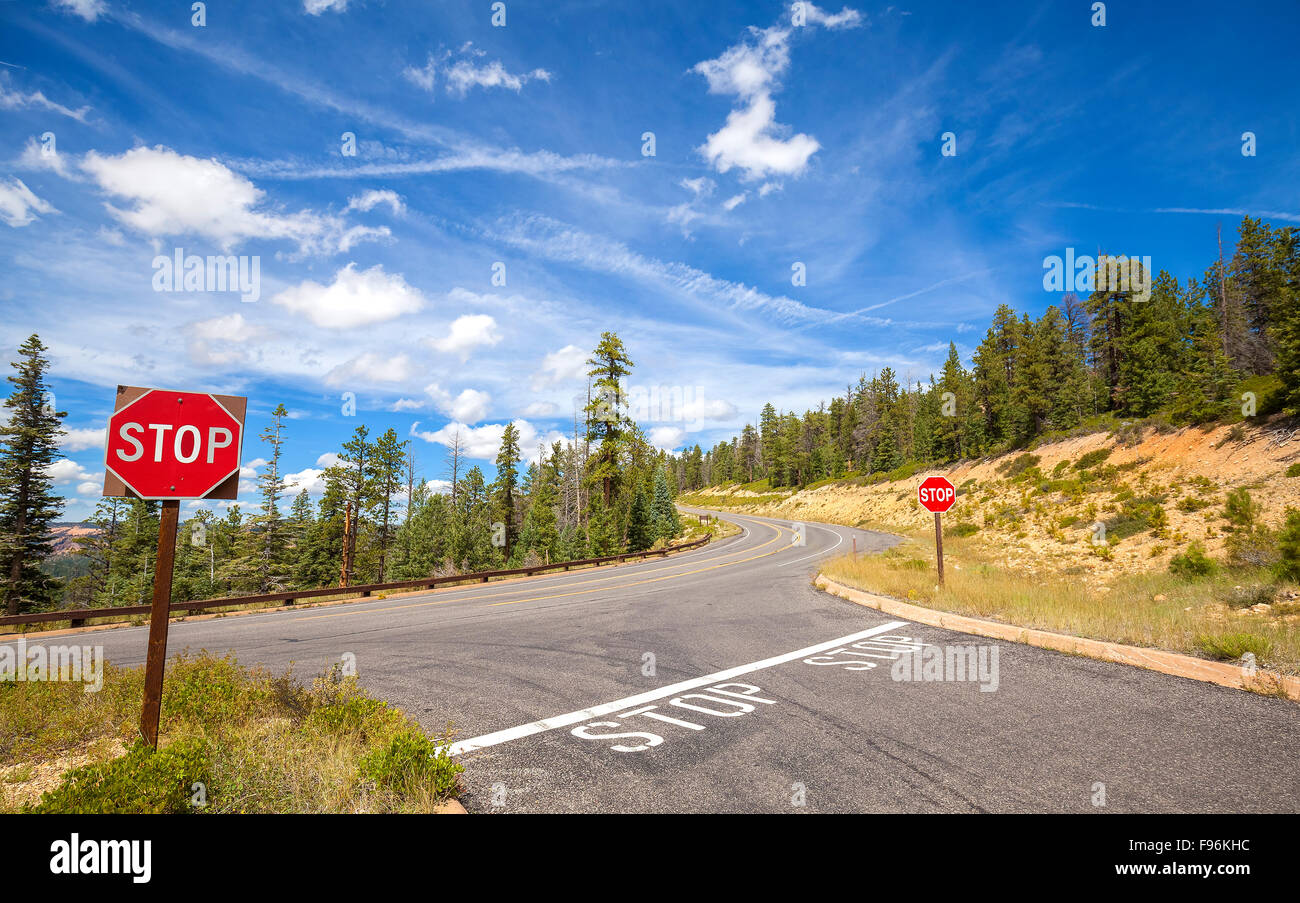 Segni di arresto dal lato di una strada vuota. Foto Stock