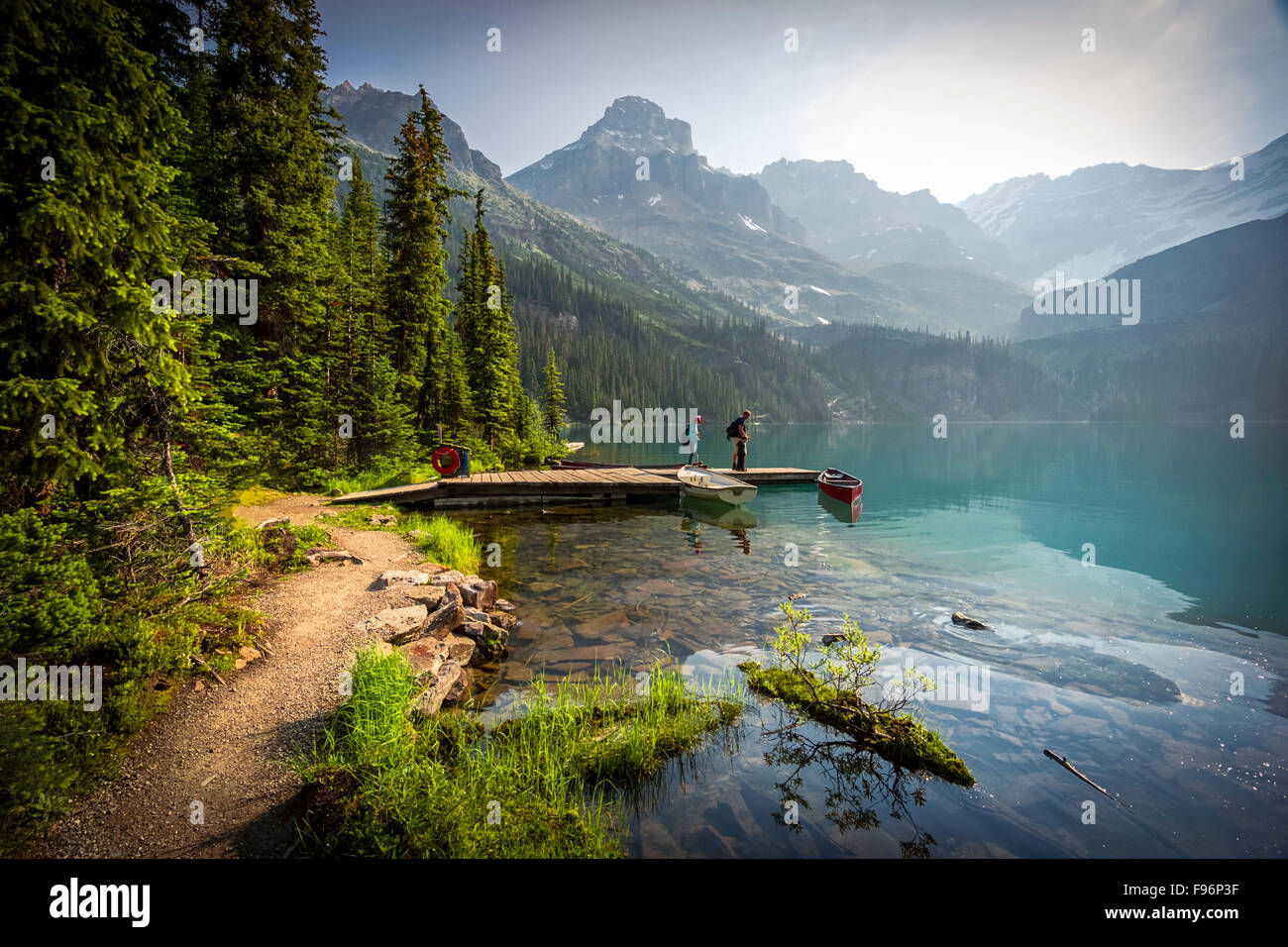 Un giovane su un dock presso il lago O'Hara nel Parco Nazionale di Yoho nelle Montagne Rocciose Canadesi Foto Stock