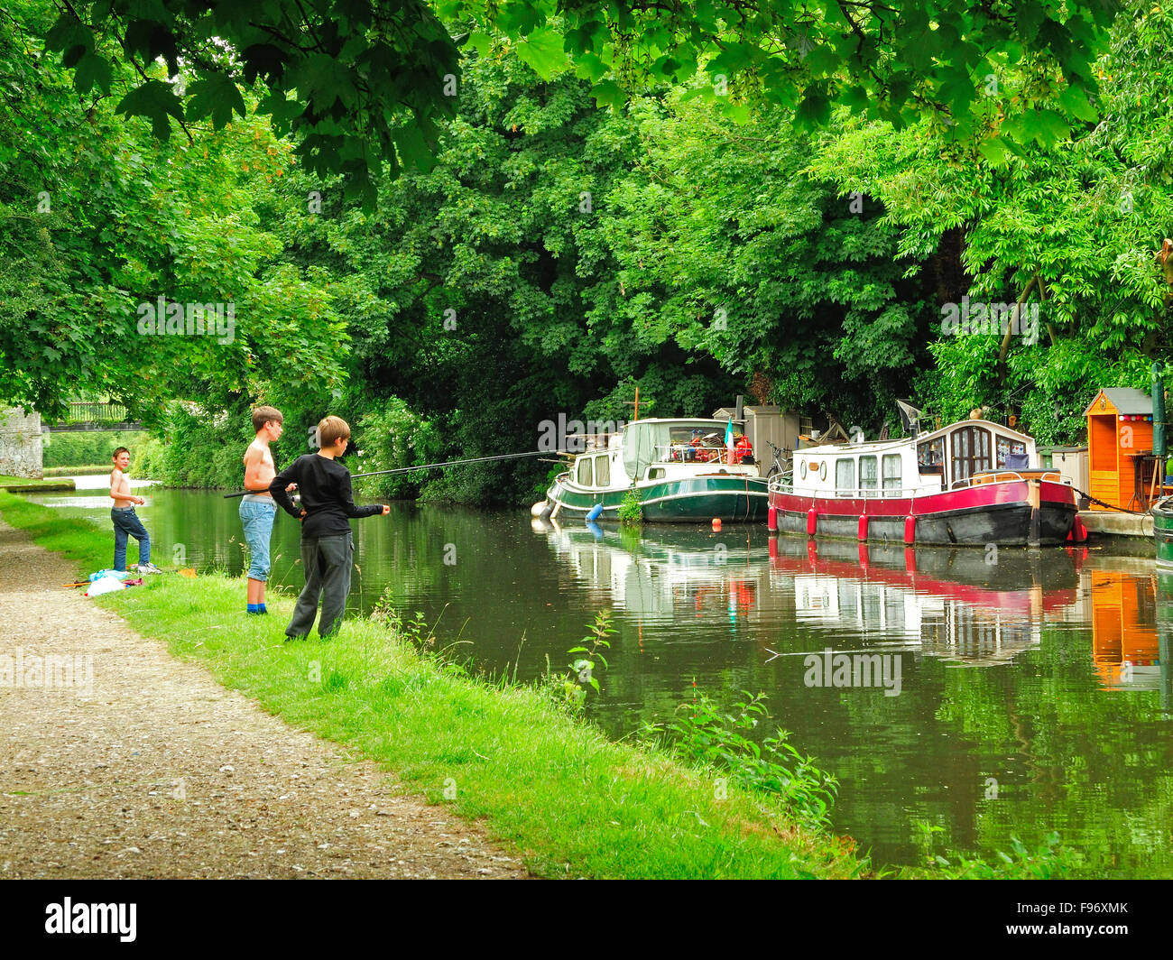 I ragazzi con attività di pesca in Grand Union Canal vicino a Hemel Hempstead, Hertfordshire, Inghilterra Foto Stock