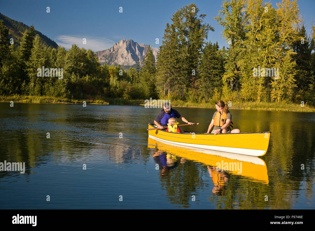 Famiglia giovane canottaggio sul lago da nubile con montatura Hosmer in background, Fernie, BC, Canada. Foto Stock
