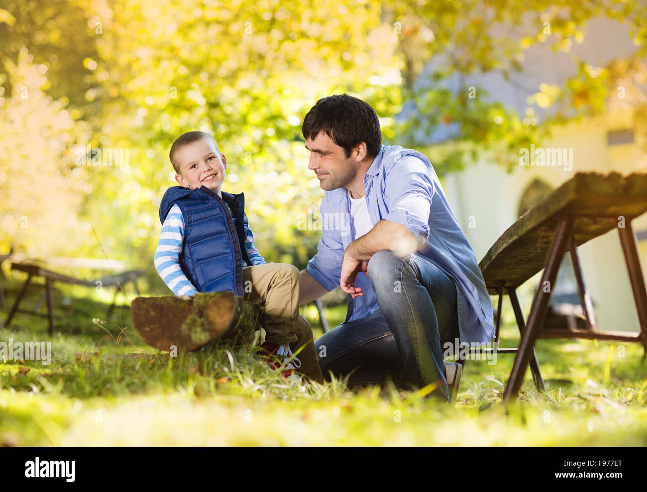 Padre e figlio di trascorrere del tempo insieme in estate la natura, Little Boy è la legatura di suo padre a scarpe Foto Stock